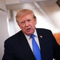 Donald Trump, con traje oscuro y corbata azul, habla ante las cámaras.