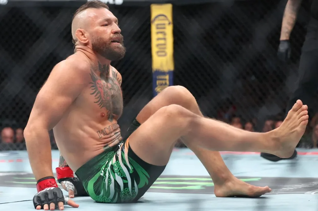 Conor McGregor, sentado en la lona dentro del octágono durante un combate de UFC.