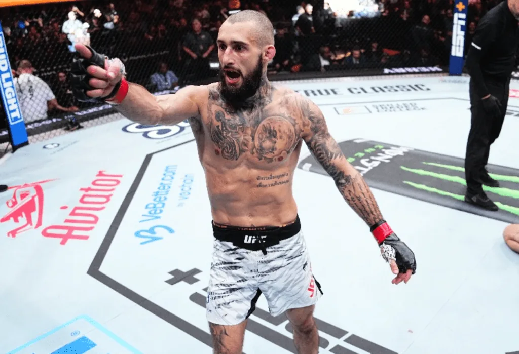 Peleador celebra su victoria dentro del octágono de UFC.