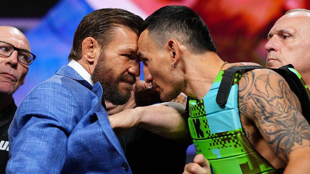 Conor McGregor and Max Holloway stand with their foreheads pressed against each other at a news conference before UFC 329