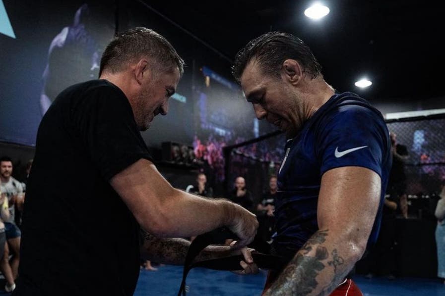 Conor McGregor, right, receiving his jiu-jitsu black belt from coach John Kavanagh